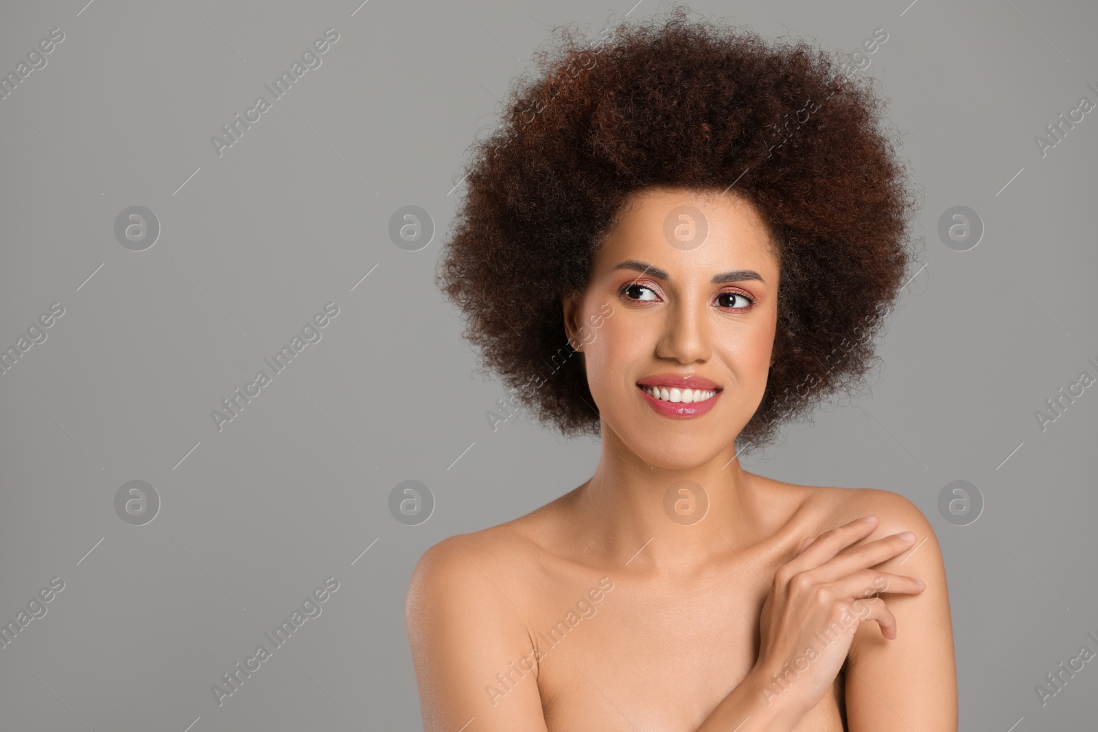 Photo of Portrait of beautiful young woman with glamorous makeup on grey background. Space for text