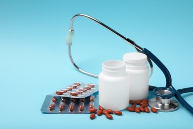 Photo of Pills and stethoscope on turquoise background, space for text. Anemia treatment