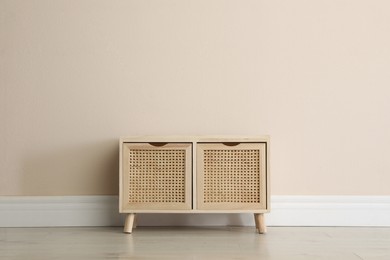 Photo of Wooden chest of drawers near beige wall indoors