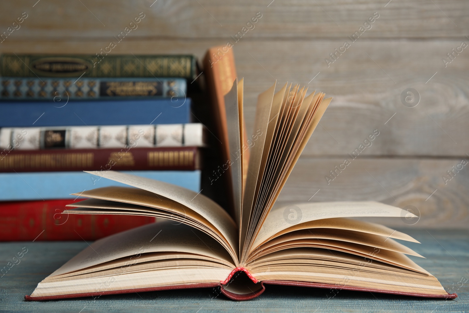 Photo of Open hardcover book on blue wooden table