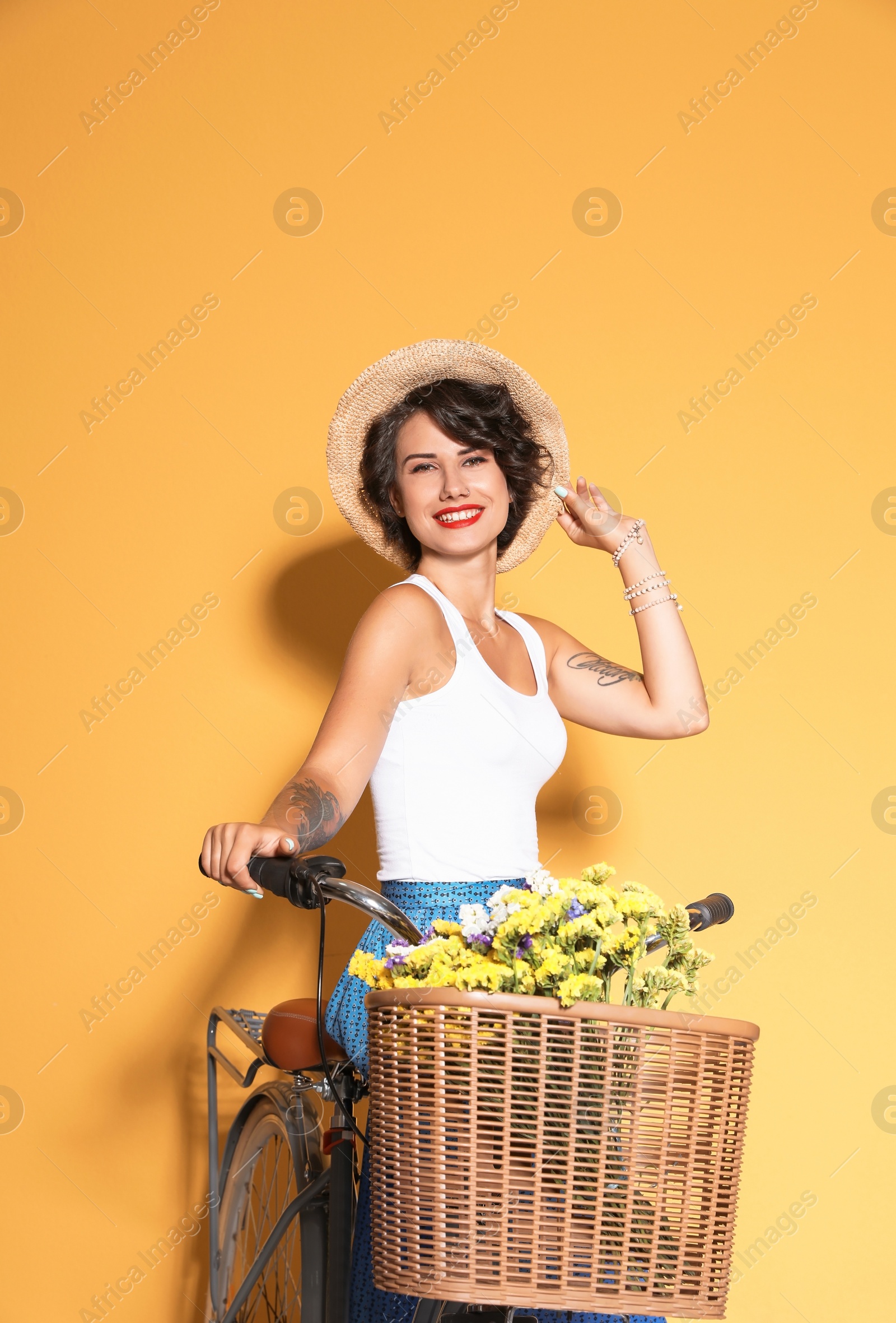 Photo of Portrait of beautiful young woman with bicycle on color background