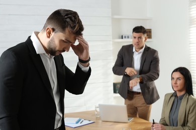 Photo of Businessman scolding employee for being late on meeting in office