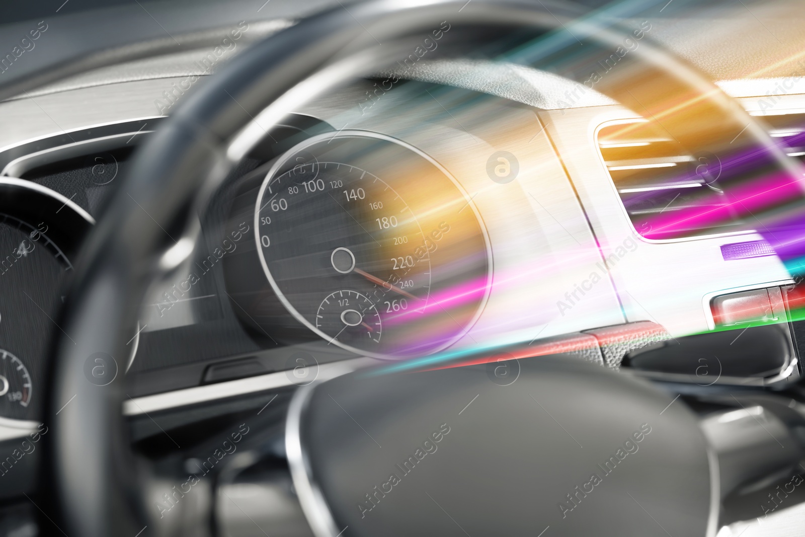 Image of Speedometer behind steering wheel in car, motion blur effect