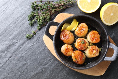 Photo of Delicious fried scallops and ingredients on dark gray textured table, flat lay. Space for text