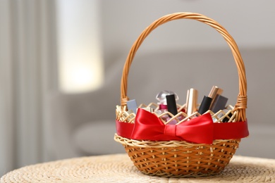 Photo of Wicker basket full of gifts in living room. Space for text