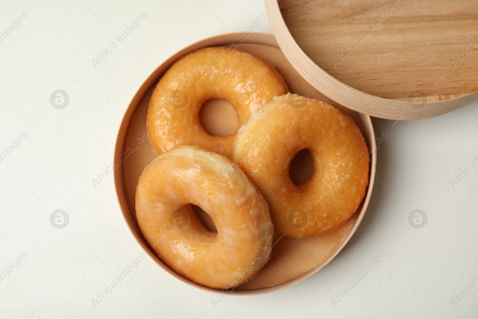 Photo of Delicious donuts on white table, top view