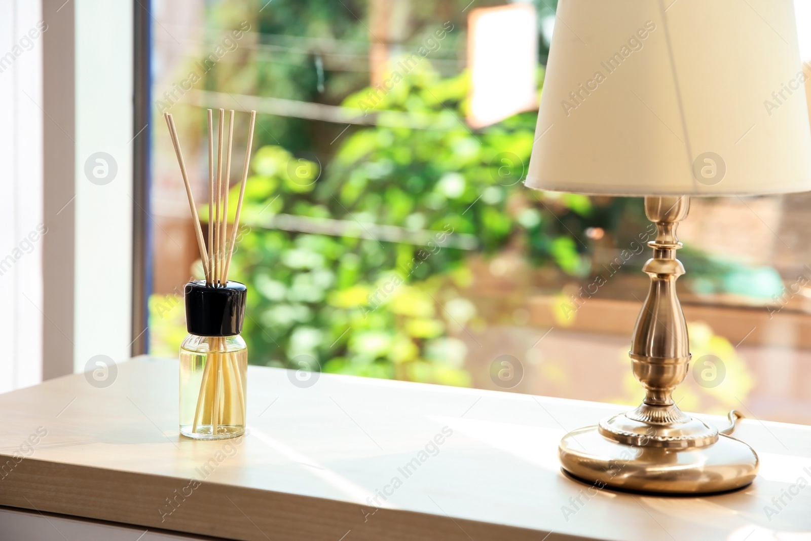 Photo of Aromatic reed air freshener on table indoors