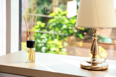 Photo of Aromatic reed air freshener on table indoors