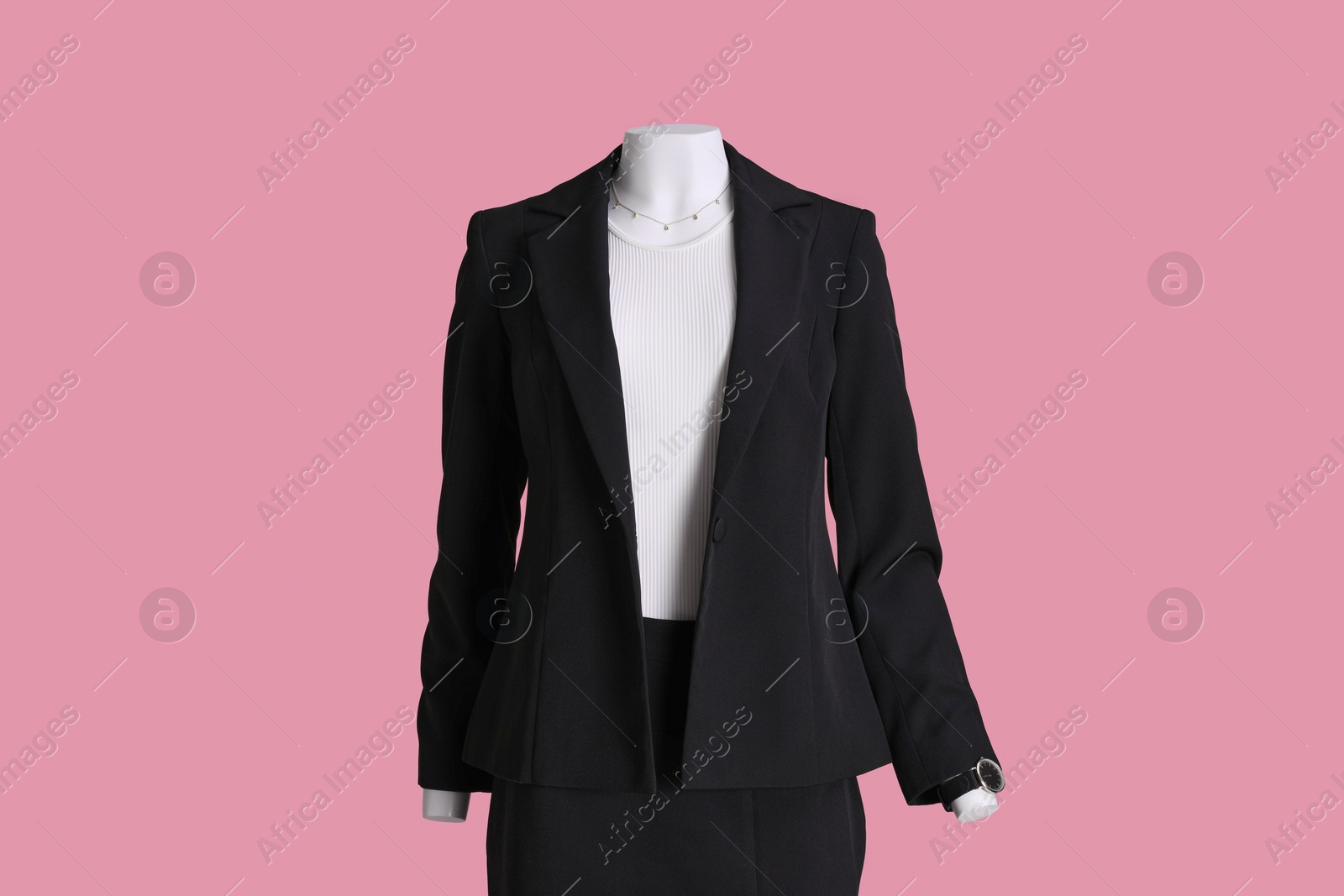 Photo of Female mannequin with accessories dressed in black classic suit and white t-shirt on pink background