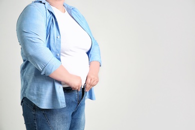 Overweight woman on light background