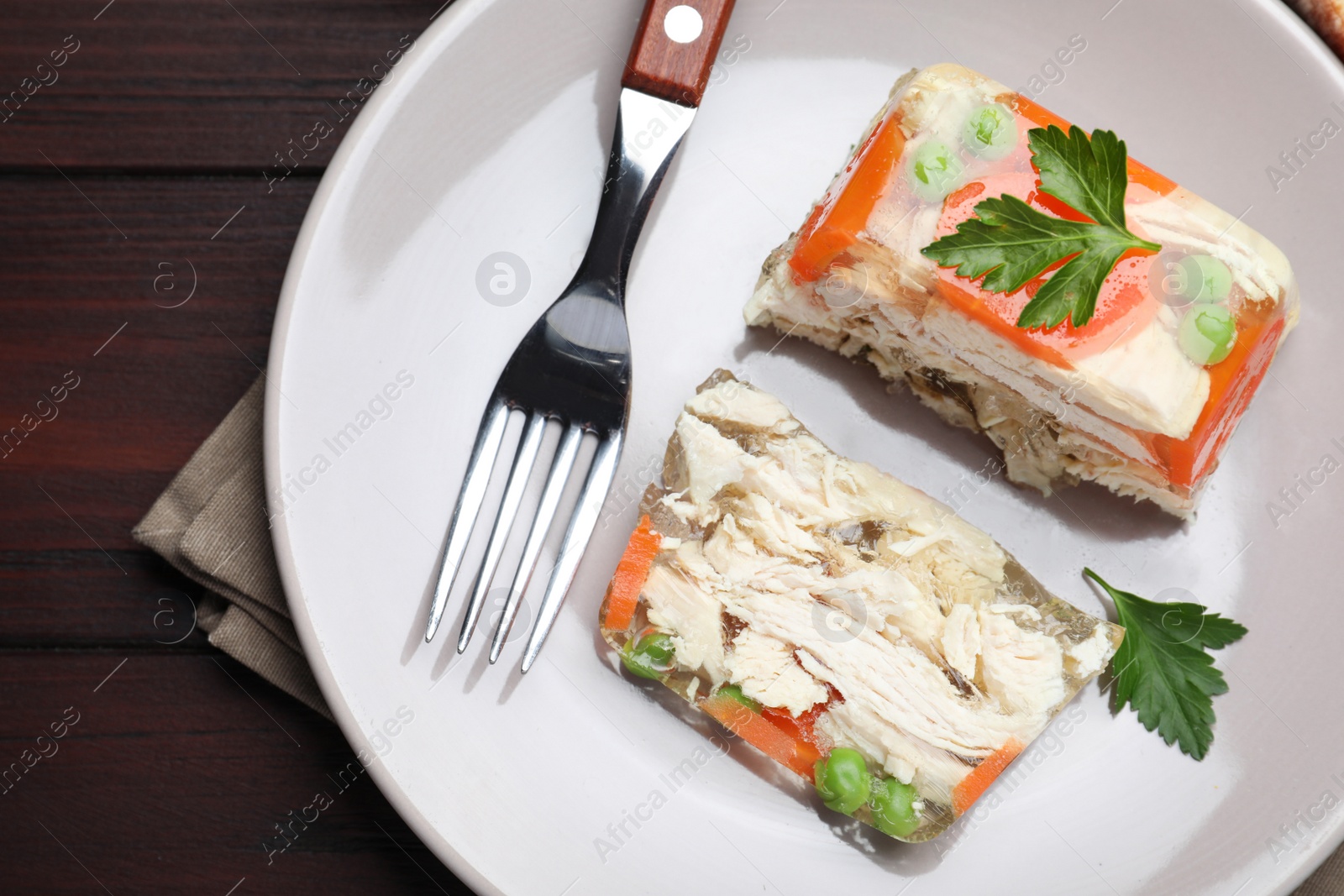 Photo of Delicious chicken aspic served on wooden table, top view