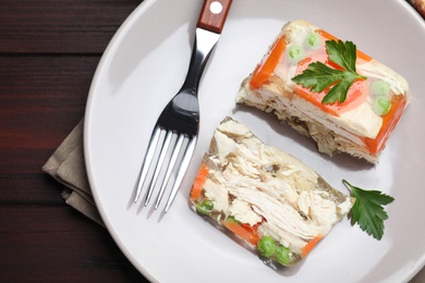 Photo of Delicious chicken aspic served on wooden table, top view