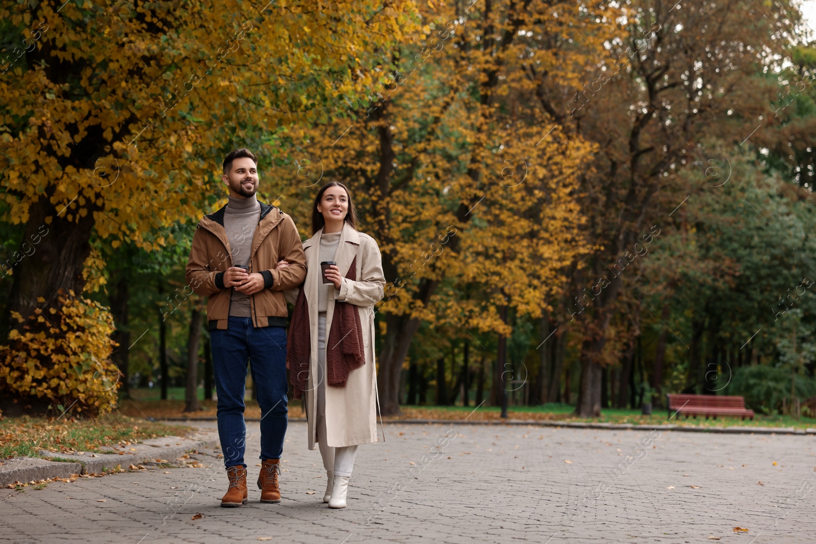 Photo of Romantic young couple spending time together in autumn park, space for text