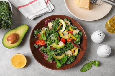 Photo of Tasty fresh kale salad on light grey table, flat lay