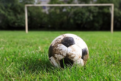 Photo of Dirty soccer ball on green grass outdoors