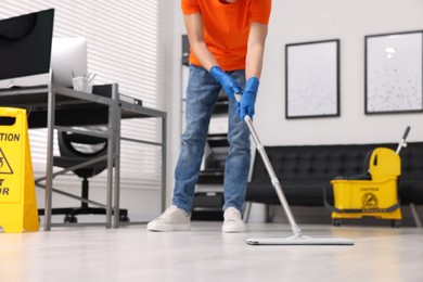 Cleaning service. Man washing floor with mop, closeup
