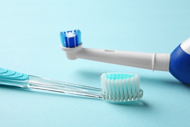 Manual and electric toothbrushes on color background. Dental care