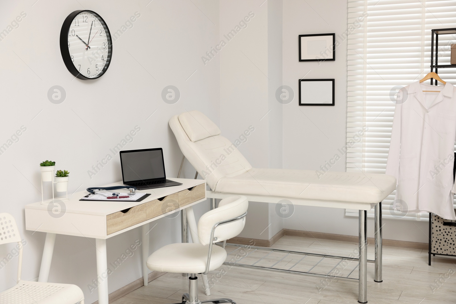 Photo of Modern medical office with doctor's workplace and examination table in clinic