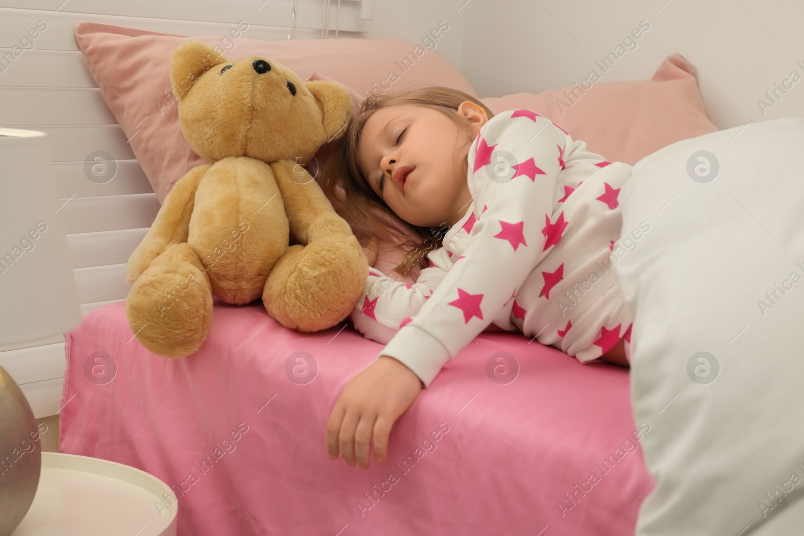 Photo of Little girl snoring while sleeping in bed at home