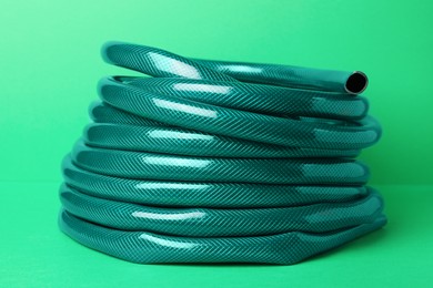 Photo of Watering hose on green background. Gardening tool