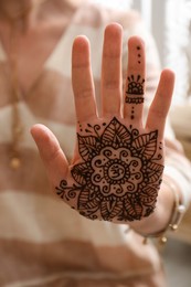 Woman with henna tattoo on palm, closeup. Traditional mehndi ornament