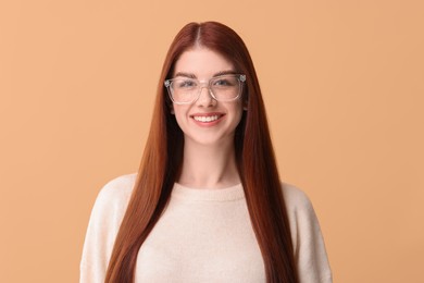 Portrait of smiling woman in glasses on beige background