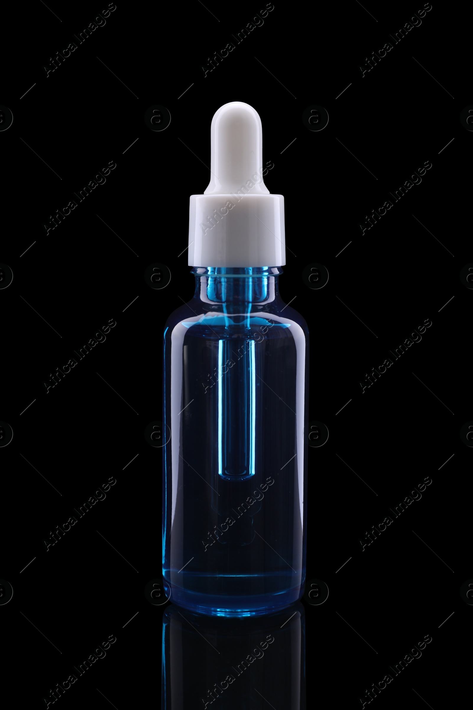 Photo of One blue bottle with tincture on mirror surface against black background