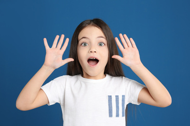 Photo of Portrait of cute little girl on blue background