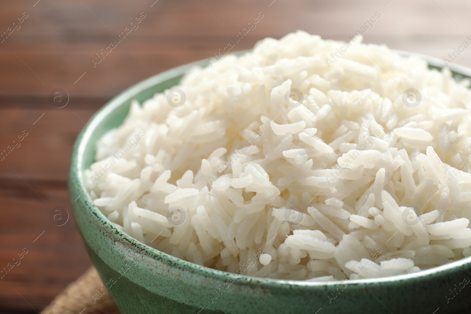 Photo of Bowl of tasty cooked white rice on table, closeup