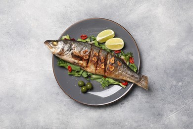Photo of Delicious sea bass fish and ingredients on light grey table, top view