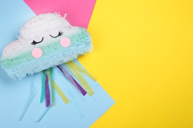 Photo of Cloud shaped pinata on color background, top view. Space for text