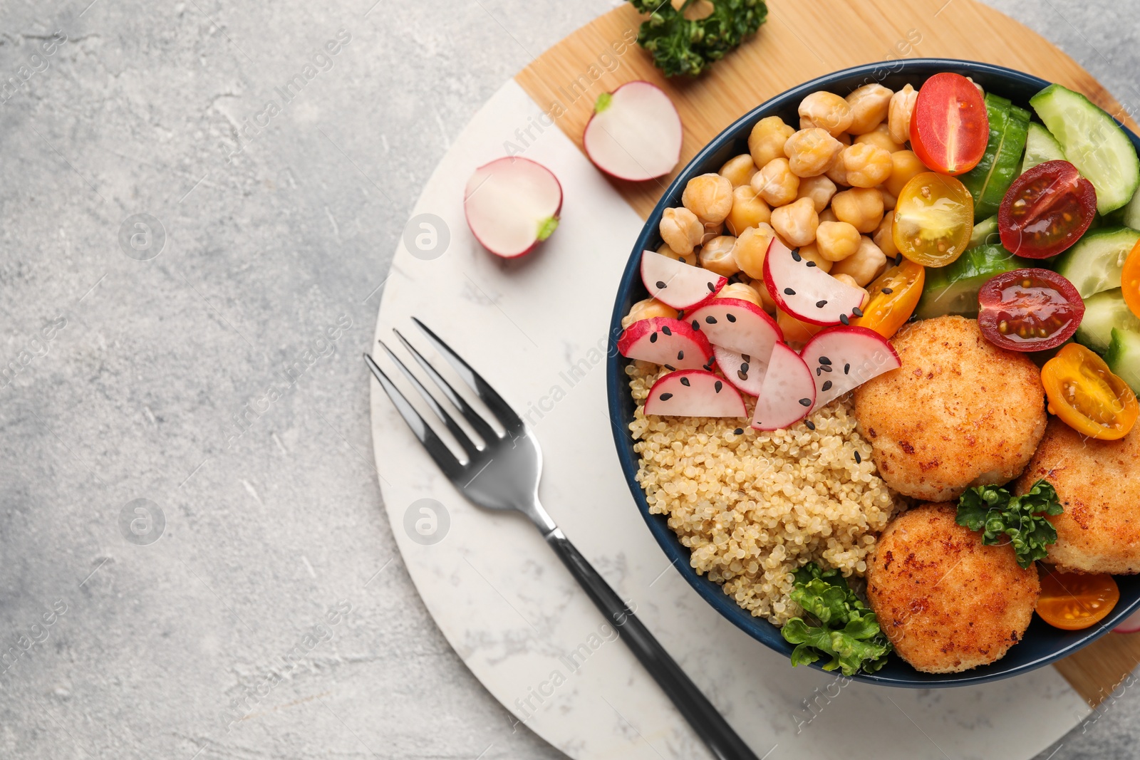 Photo of Delicious vegan bowl with chickpeas, cutlets and radish on grey table, top view. Space for text