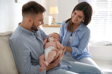 Photo of Happy couple with their newborn baby at home