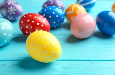 Photo of Painted Easter eggs on wooden table, space for text