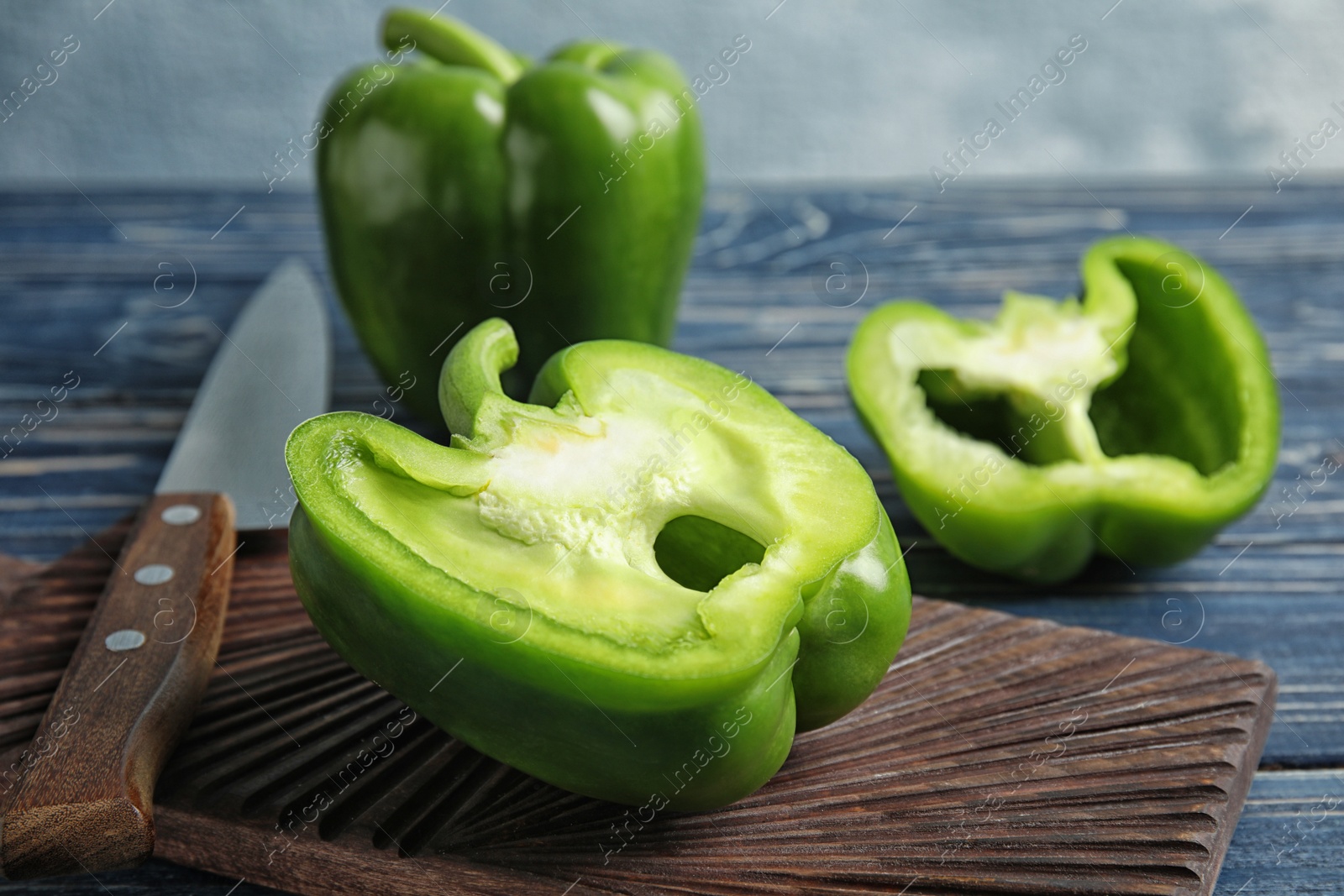 Photo of Wooden board with cut paprika pepper on table, closeup