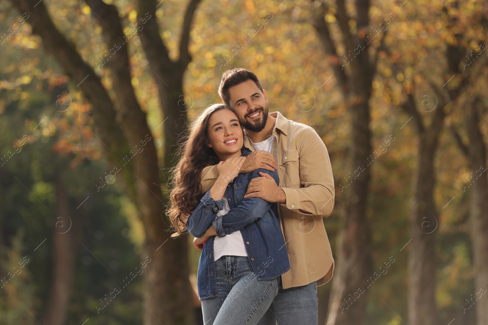 Photo of Beautiful young couple hugging in park on autumn day