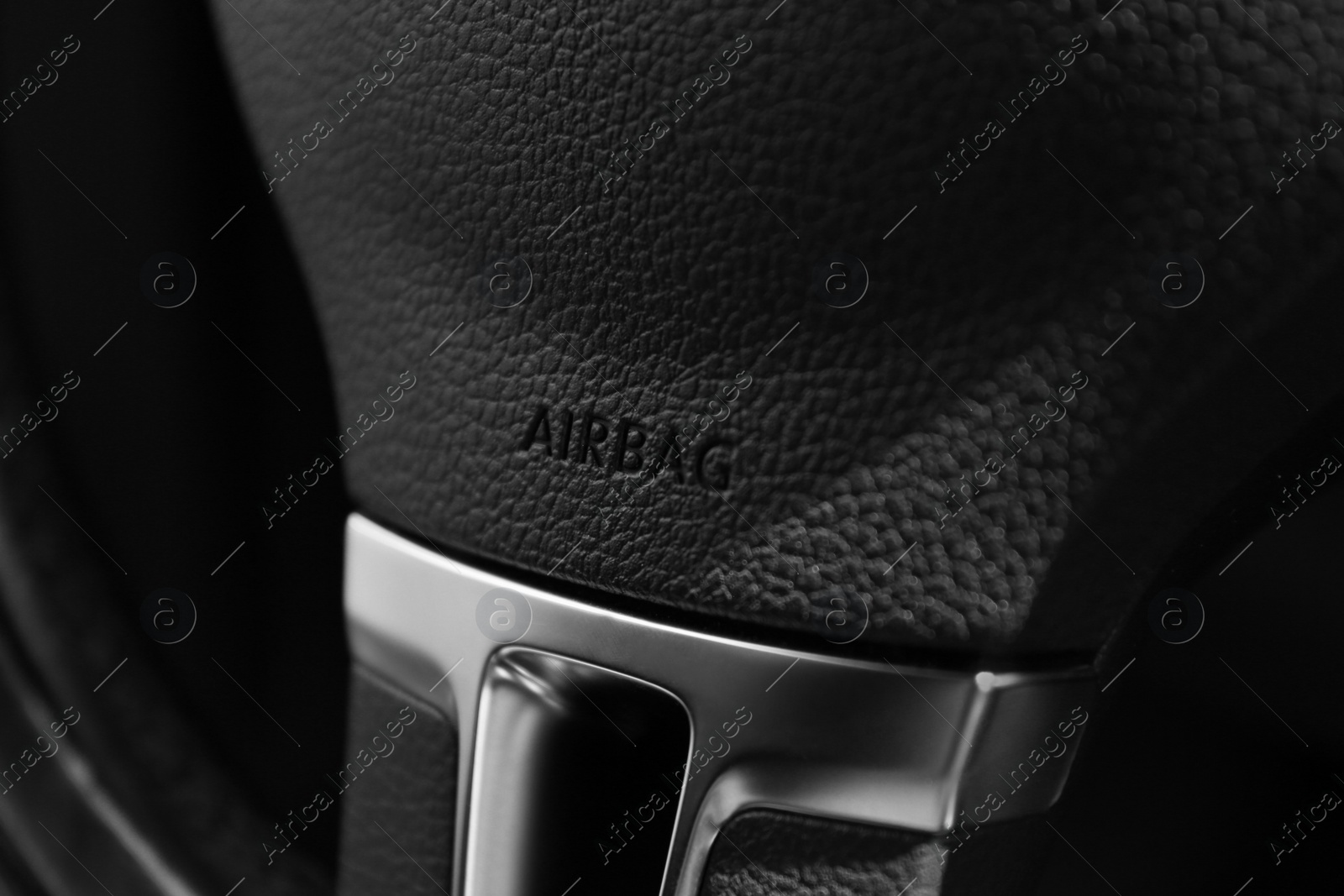 Photo of Safety airbag sign on steering wheel in car, closeup