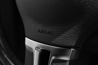 Photo of Safety airbag sign on steering wheel in car, closeup