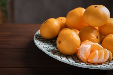 Photo of Fresh tangerines on wooden table. Citrus fruit