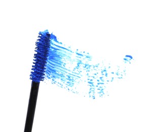 Applicator and blue mascara smear on white background, top view