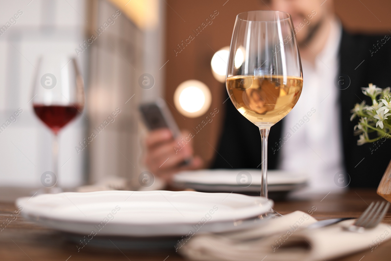 Photo of Glass of delicious wine and blurred man on background