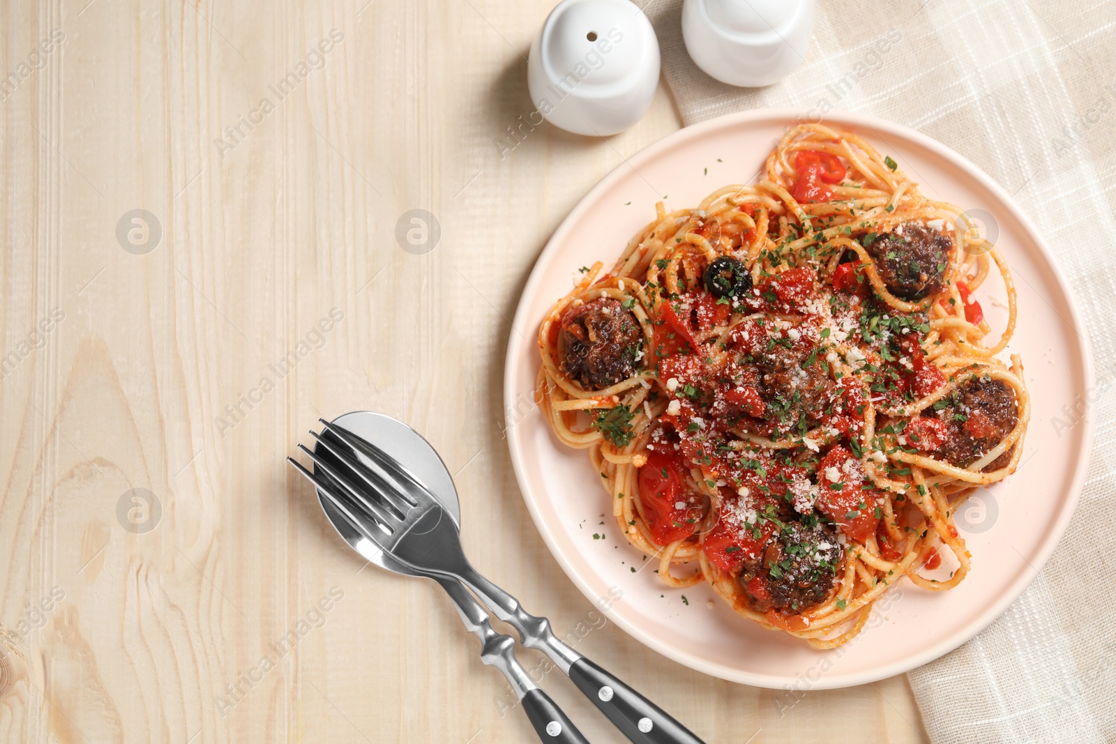 Photo of Delicious pasta with meatballs and tomato sauce served on wooden table, flat lay. Space for text