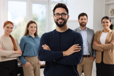Photo of Portrait of happy businessman and his team in office