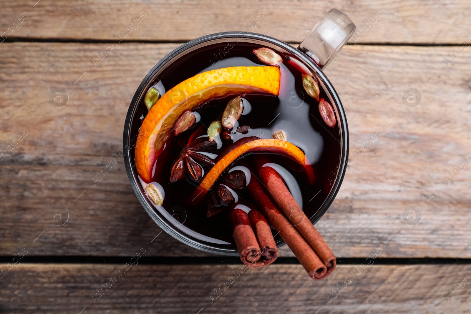 Photo of Aromatic mulled wine on wooden table, top view