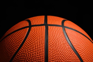 Photo of Orange basketball ball on black background, closeup