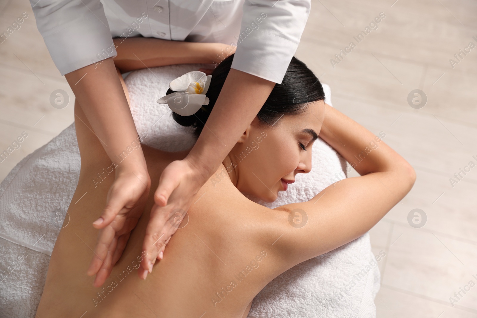 Photo of Beautiful woman receiving back massage in beauty salon, closeup