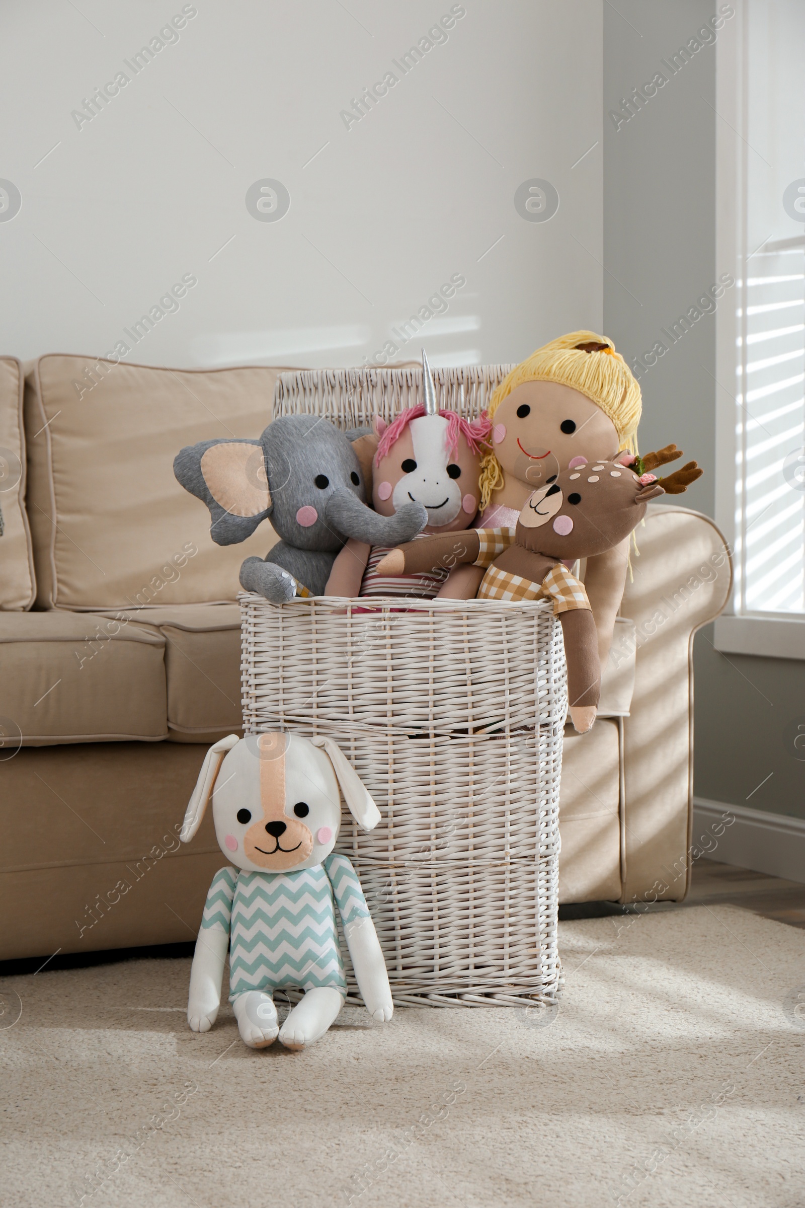 Photo of Funny stuffed toys and basket in children's room. Interior decor