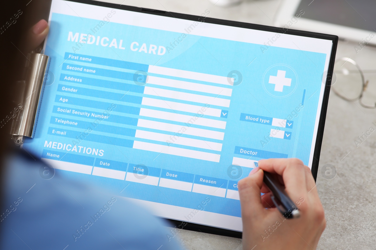 Photo of Doctor filling patient's medical card in clinic, closeup