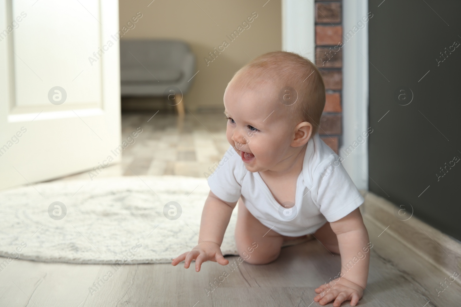 Photo of Cute little baby crawling on floor indoors, space for text