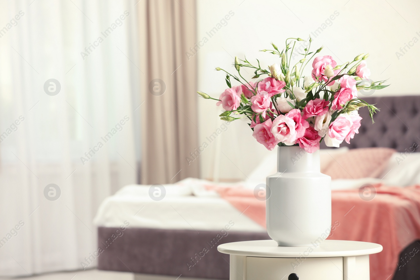 Photo of Vase with beautiful flowers on table in bedroom, space for text